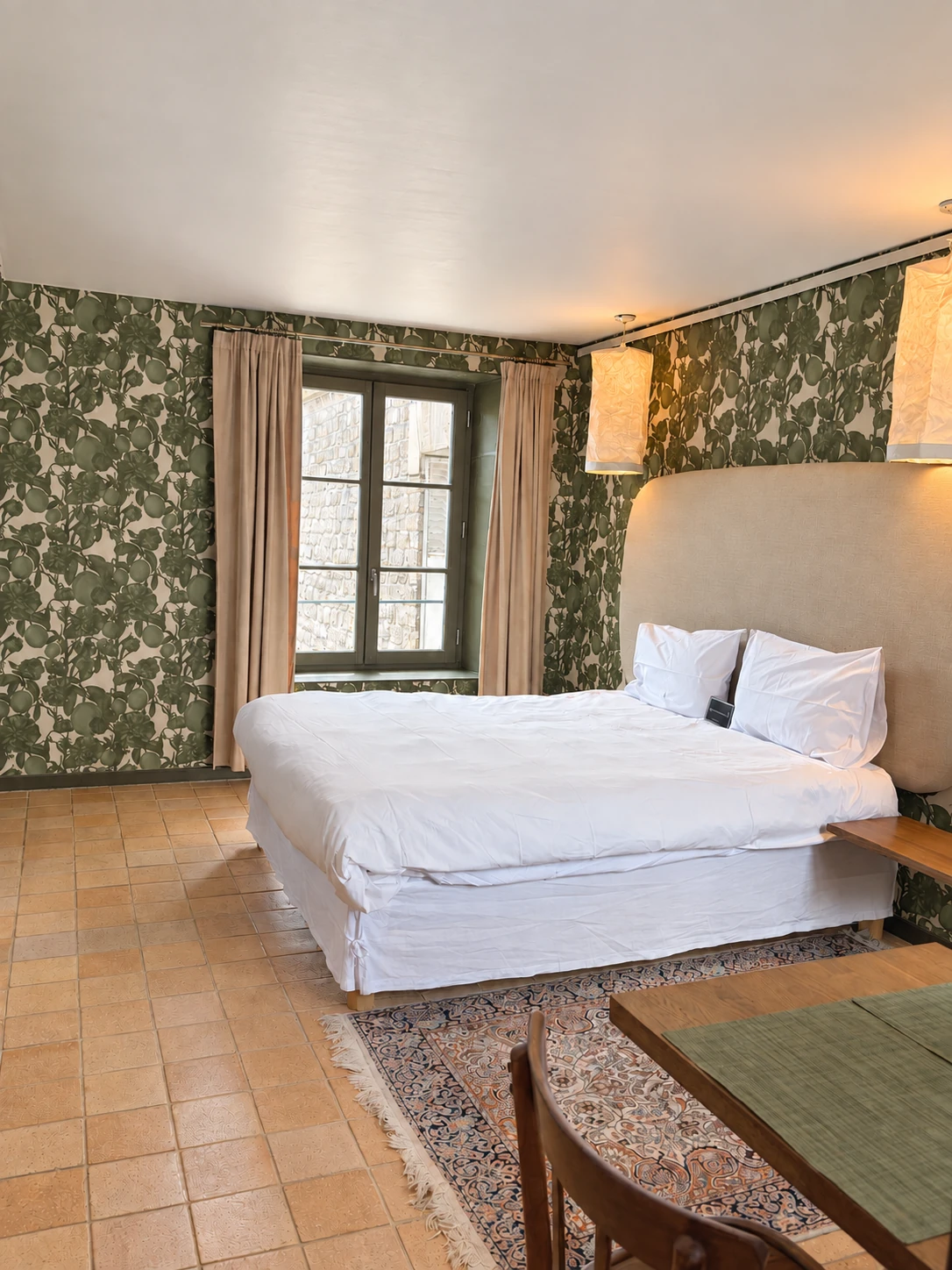 Le lit double de l’appartement et sa tête de lit claire