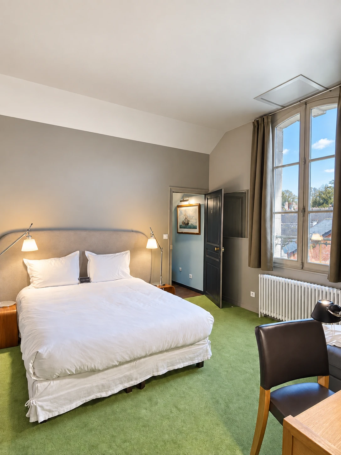 Das Doppelbett des Deluxe Zimmers in der Nähe des großen Fensters