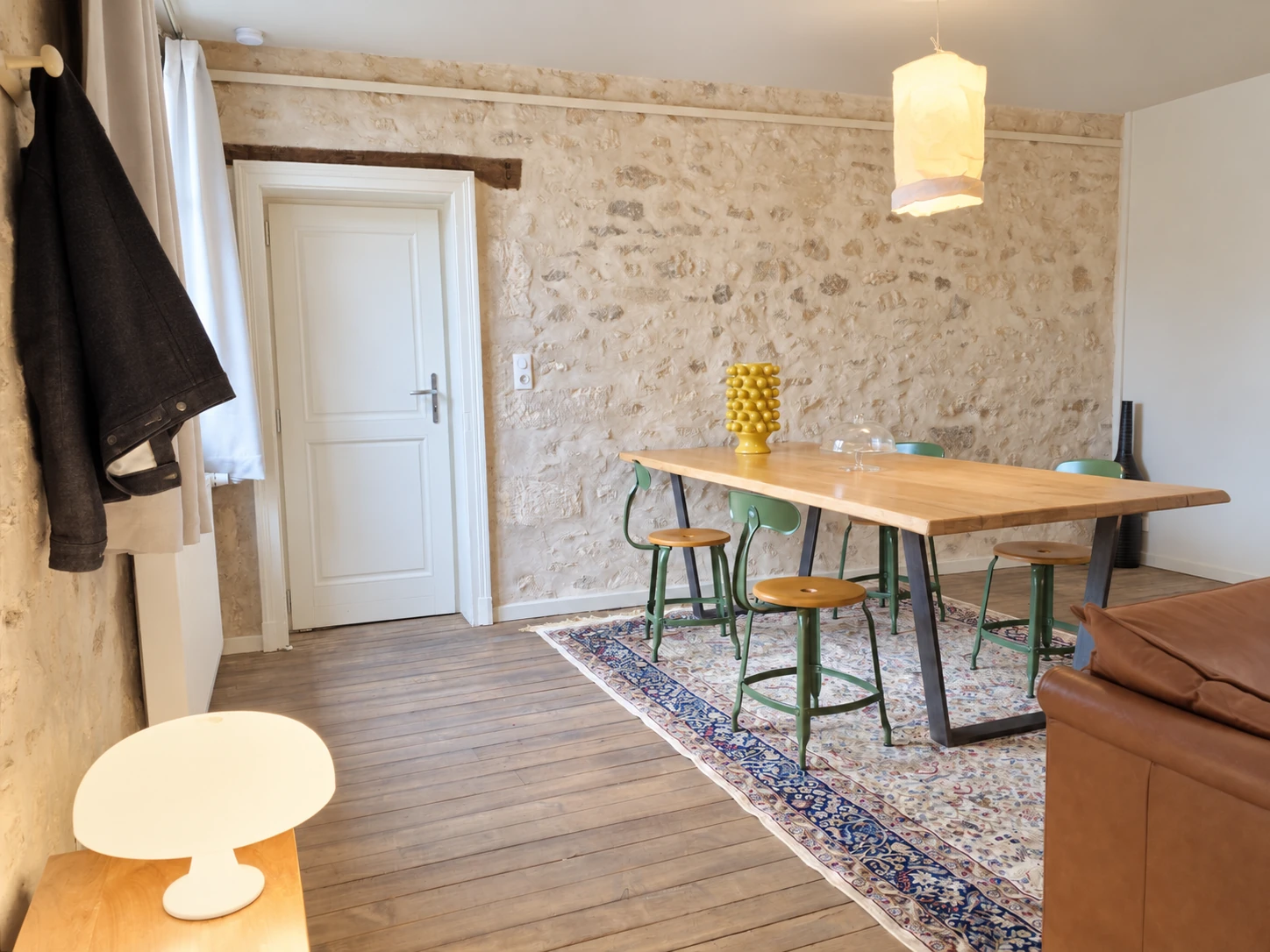 Esstisch und Stühle von Apartment Nr. 6 vor der Steinwand